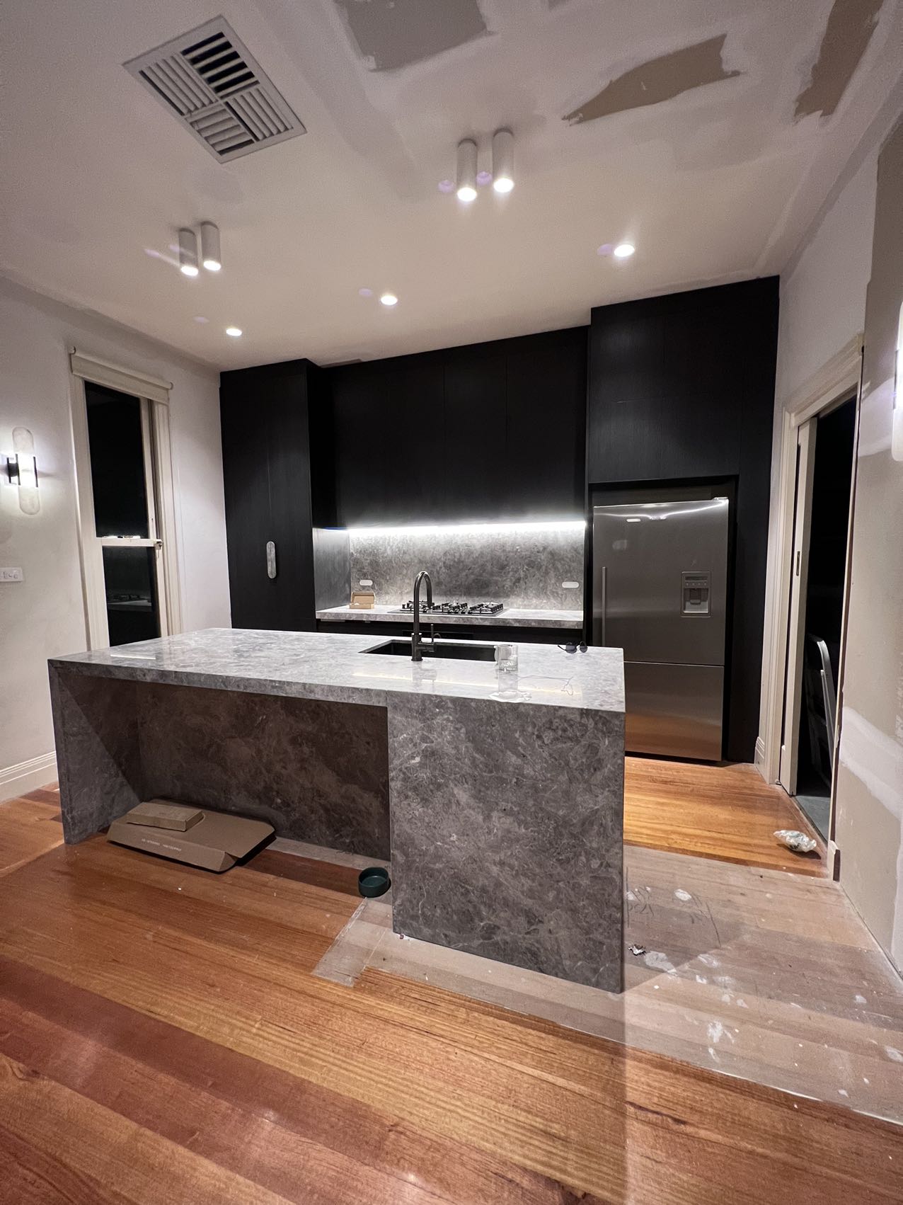 Dark stone kitchen renovation during final installation in Melbourne
